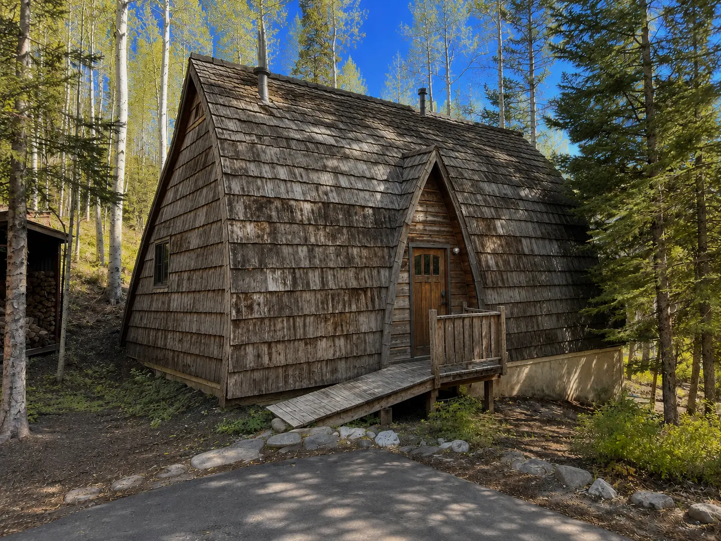 Mountain cabin with a weathered wood shingle roof before its metal roof upgrade