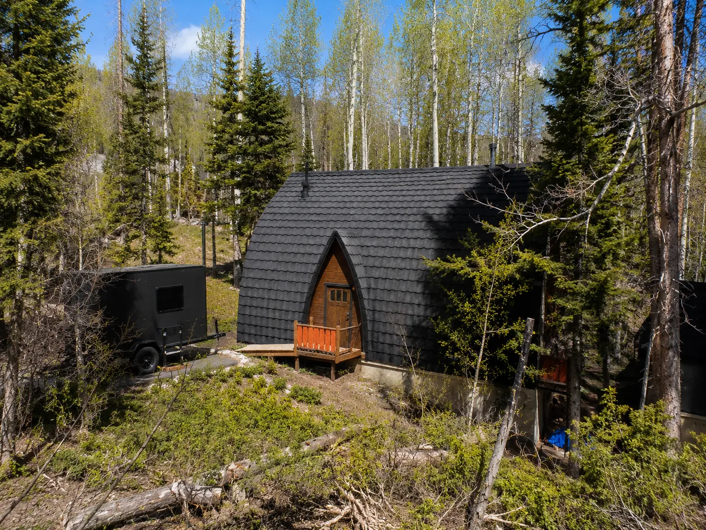 The same cabin after installation of a charcoal metal shingle roof by Otter Roofing